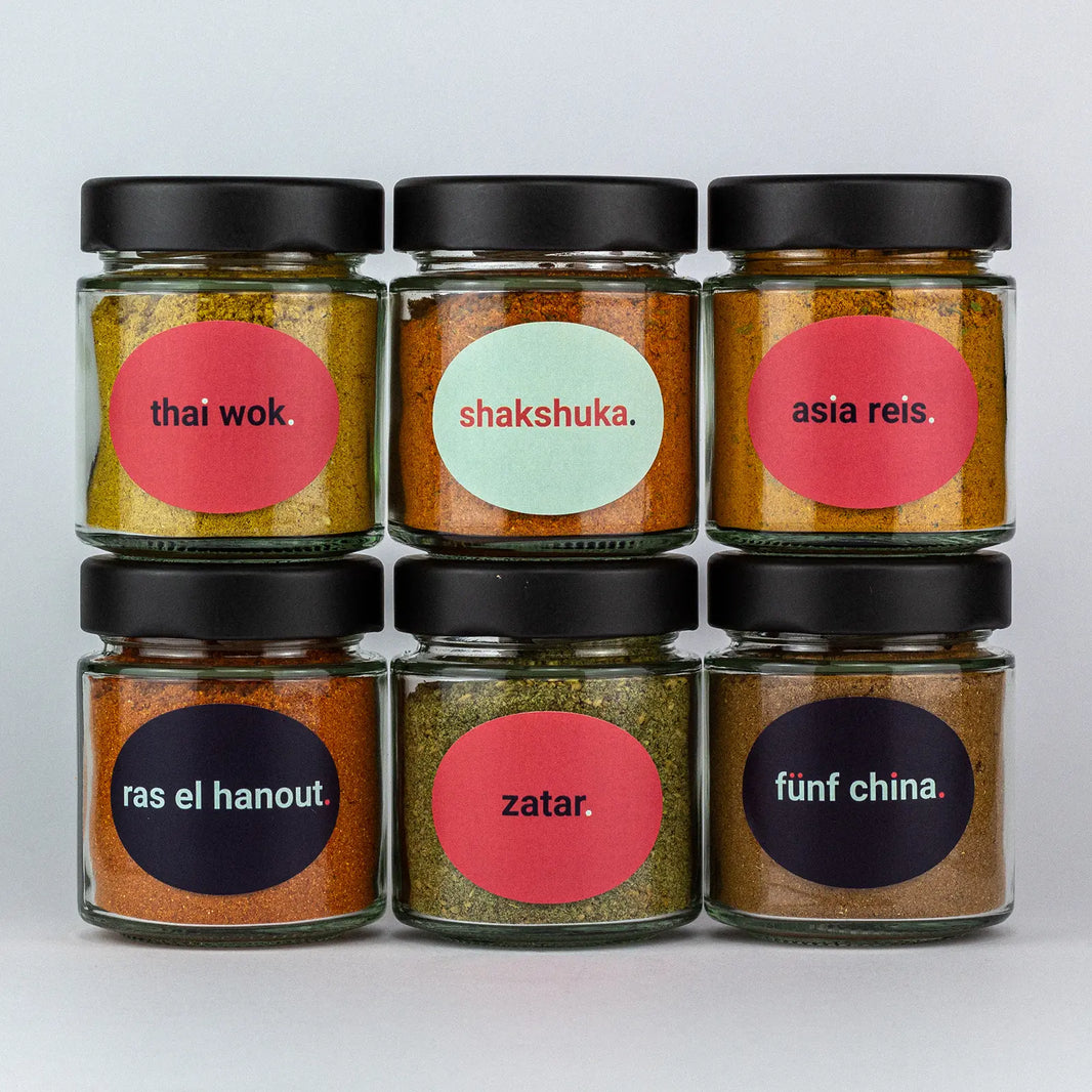 Die Gewürze des Asia Orient Set Thai Wok, Shakshuka, Asia Reis, Ras el Hanout, Zatar und Fünf China in Gläsern aufeinandergestapelt.