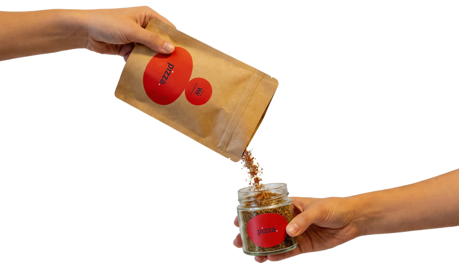 Ein Gewürzglas wird aus einem nachhaltigen Nachfüllbeutel mit Gewürz aufgefüllt.