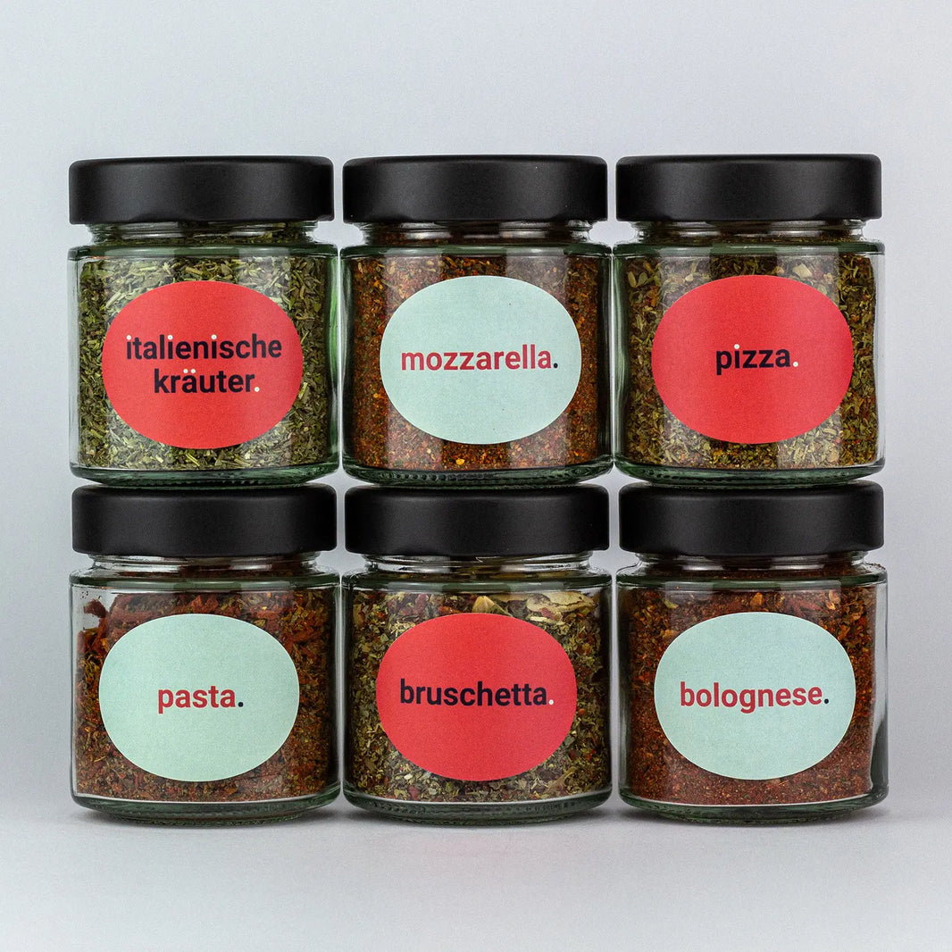 Die Gewürze des Italienisch Set Italienische Kräuter, Mozzarella, Pizza, Pasta, Bruschetta und Bolognese in Gläsern aufeinandergestapelt.