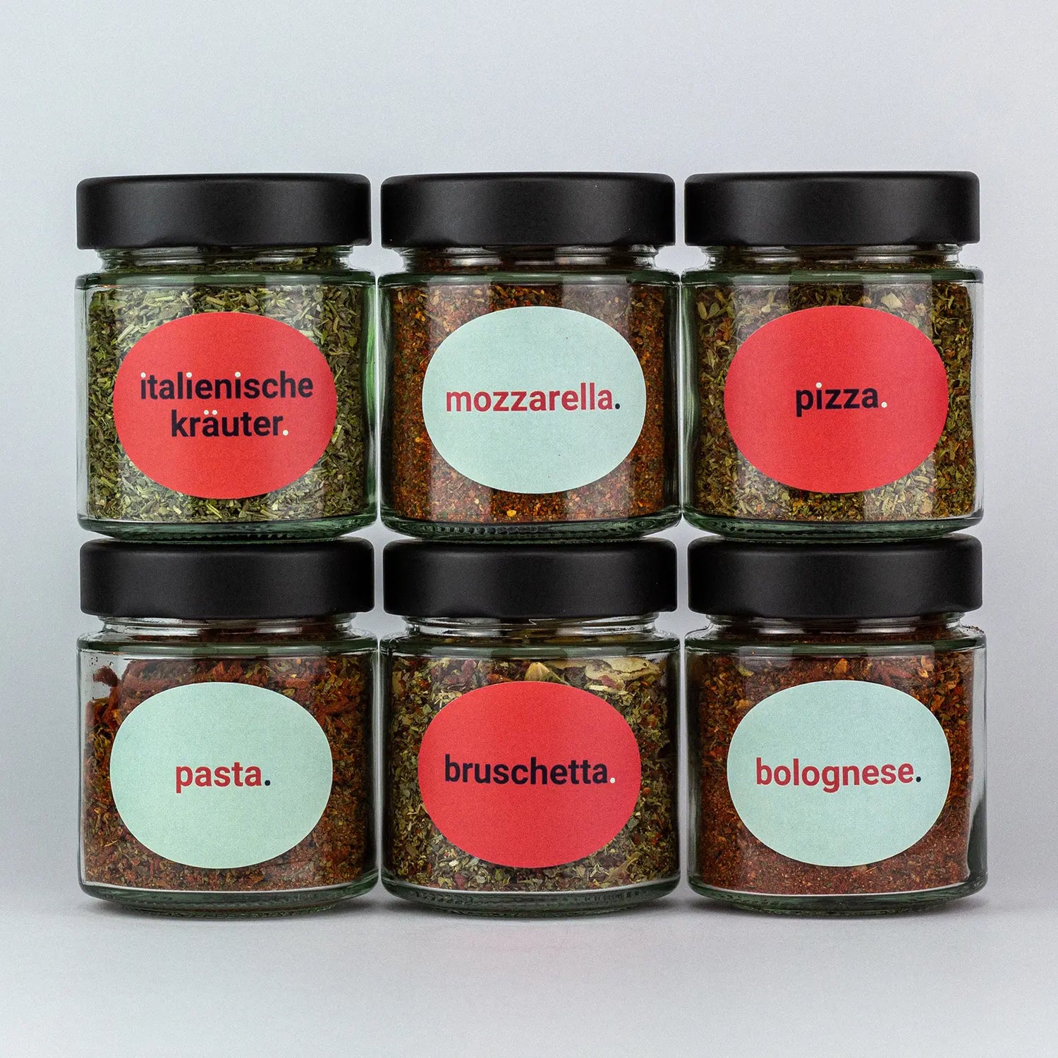 Die Gewürze des Italienisch Set Italienische Kräuter, Mozzarella, Pizza, Pasta, Bruschetta und Bolognese in Gläsern aufeinandergestapelt.