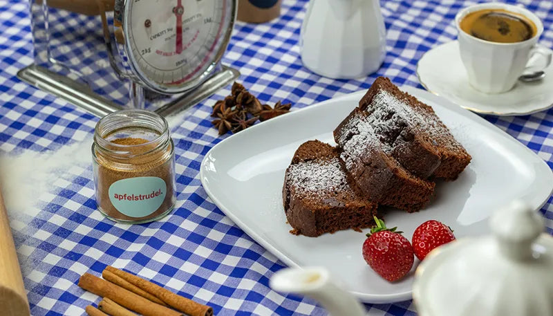Das Kategoriebild für Kaffee und Kuchen. Es ist das Gewürz Apfelstrudel zu sehen neben einem Kuchen, Erdberren und Milch.
